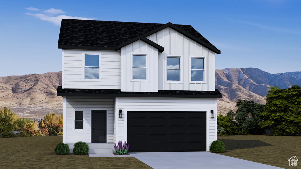 View of front of property with board and batten siding, a mountain view, concrete driveway, an attached garage, and a front lawn