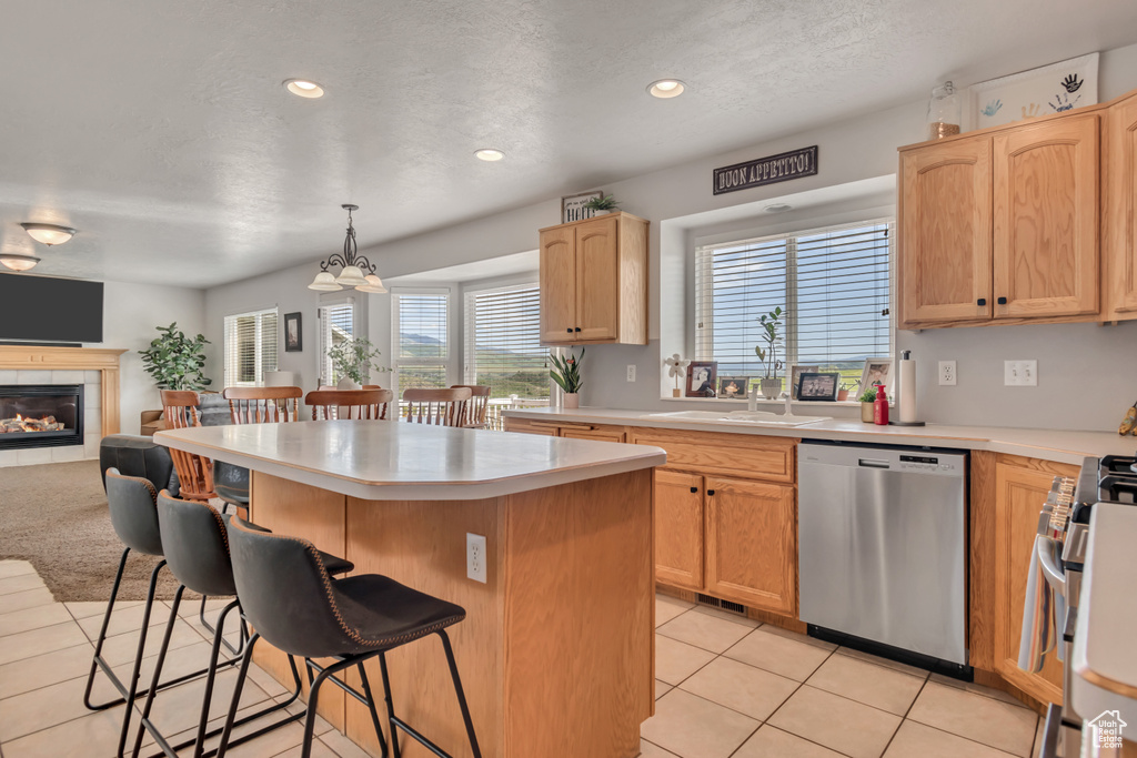 Kitchen featuring stainless steel appliances, a kitchen breakfast bar, a kitchen island, light brown cabinetry, and open floor plan