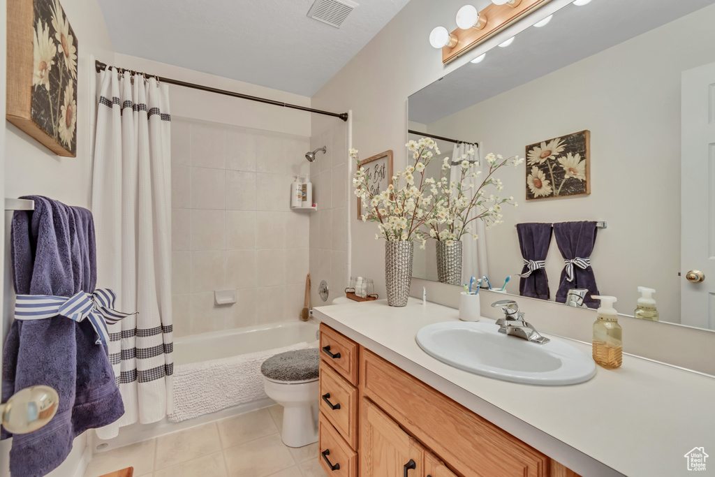 Full bathroom with vanity, shower / bath combo, and tile patterned floors