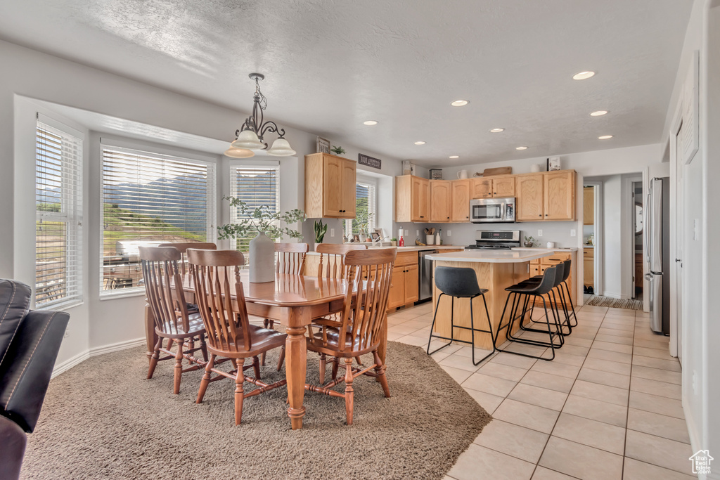 Dining space with recessed lighting and light tile patterned floors
