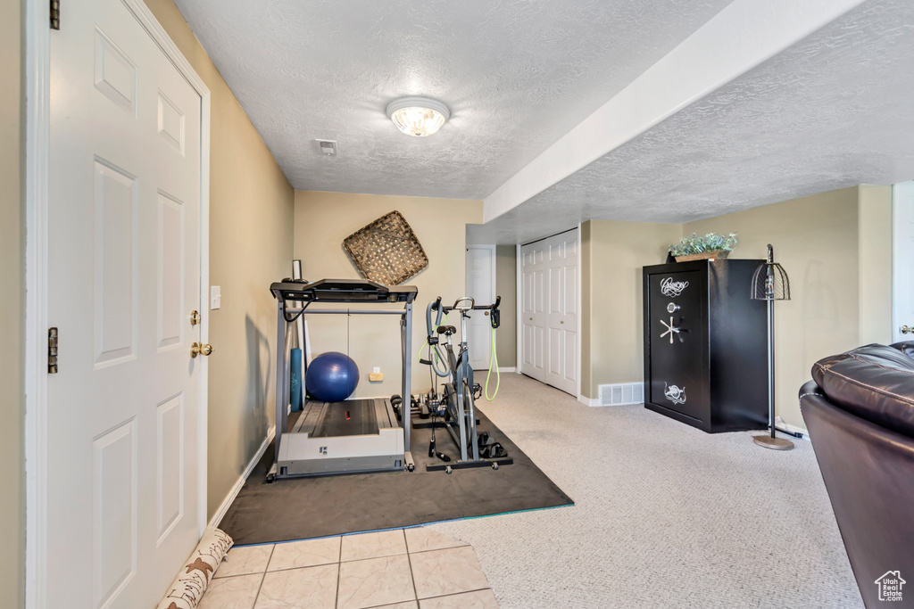 Workout area featuring a textured ceiling and carpet floors