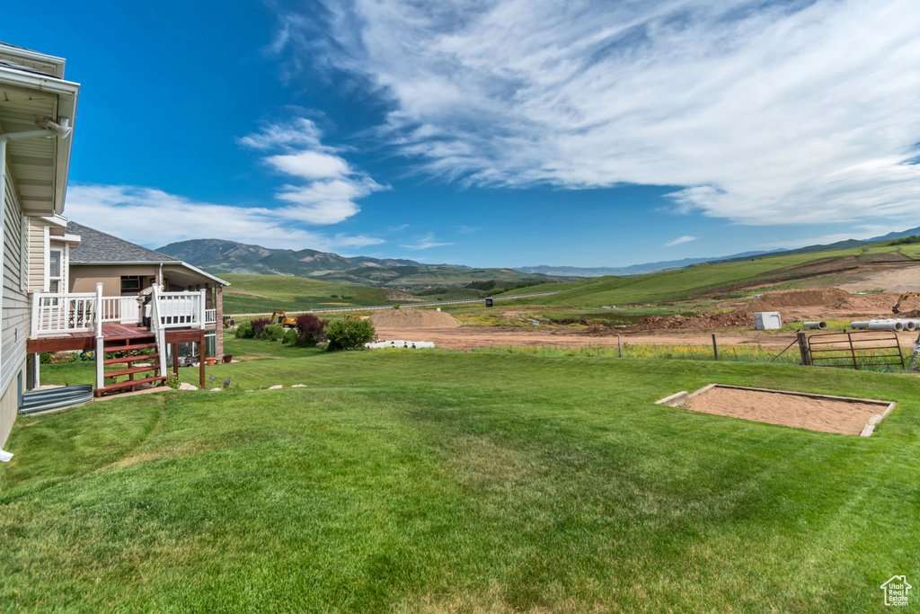 View of yard with a deck with mountain view and a rural view