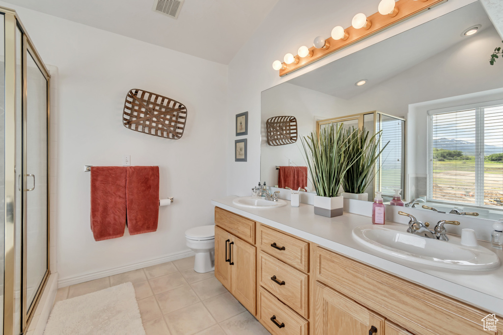 Full bath with a shower with door, double vanity, tile patterned flooring, and lofted ceiling