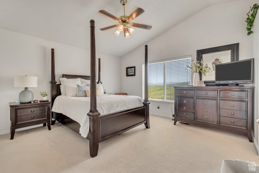 Bedroom with light colored carpet, a ceiling fan, and high vaulted ceiling