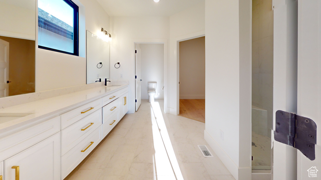 Full bathroom with double vanity and marble look tile flooring