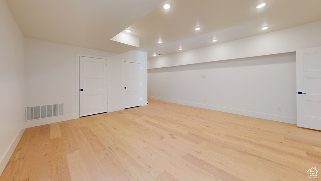 Finished below grade area with light wood finished floors and recessed lighting
