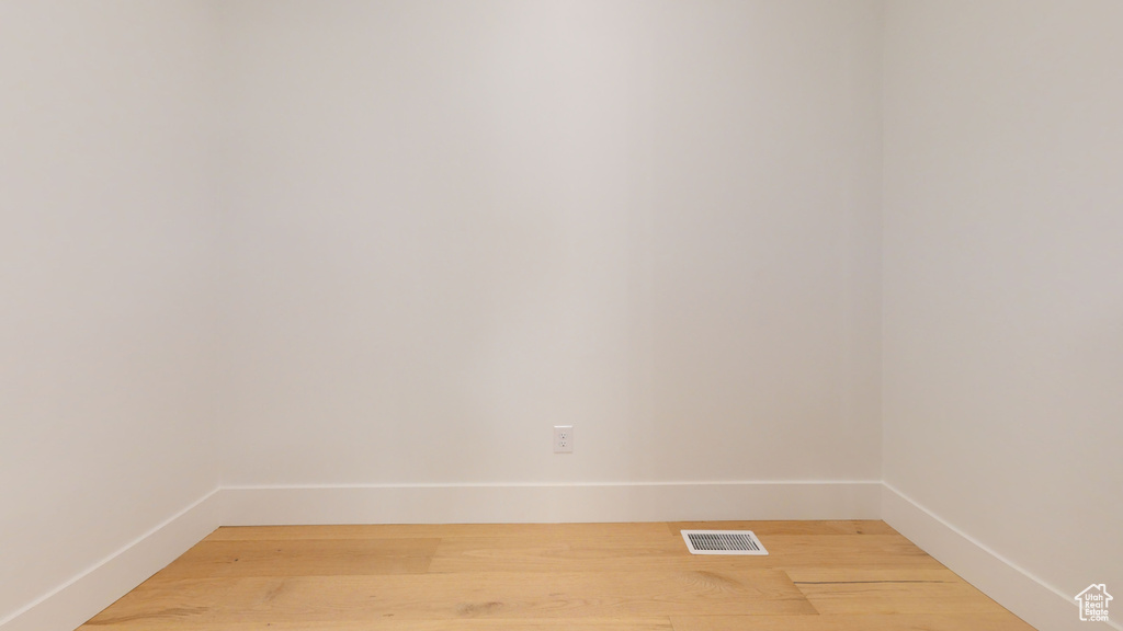 Empty room with light wood-type flooring and baseboards