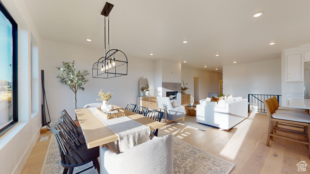 Dining space with light wood-style flooring, recessed lighting, and a chandelier