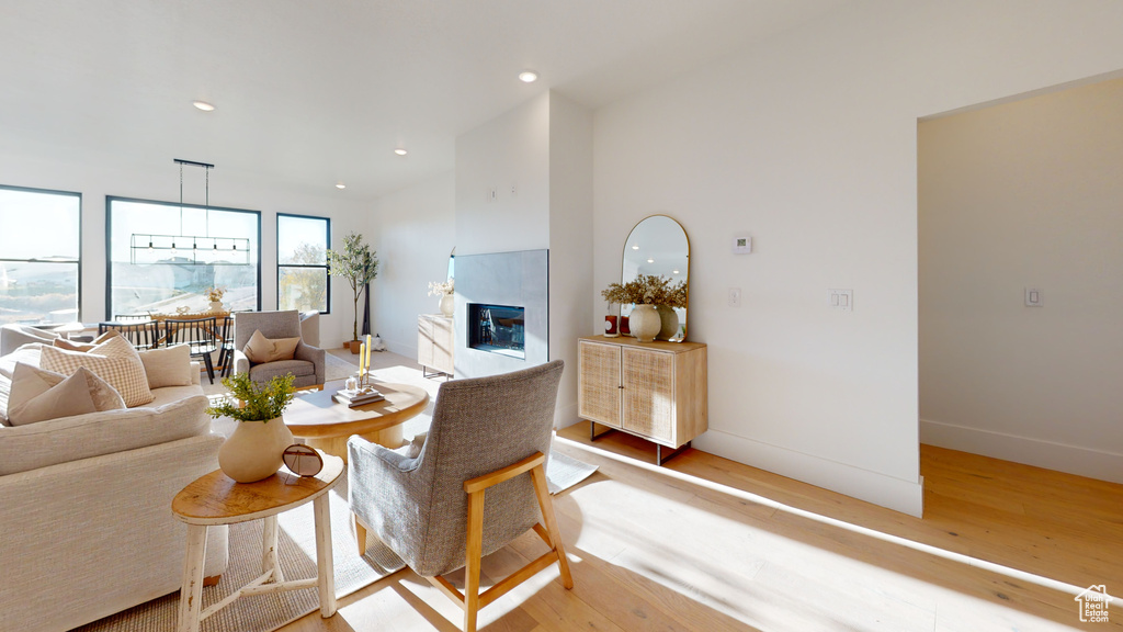 Living room featuring light wood finished floors, a premium fireplace, and recessed lighting