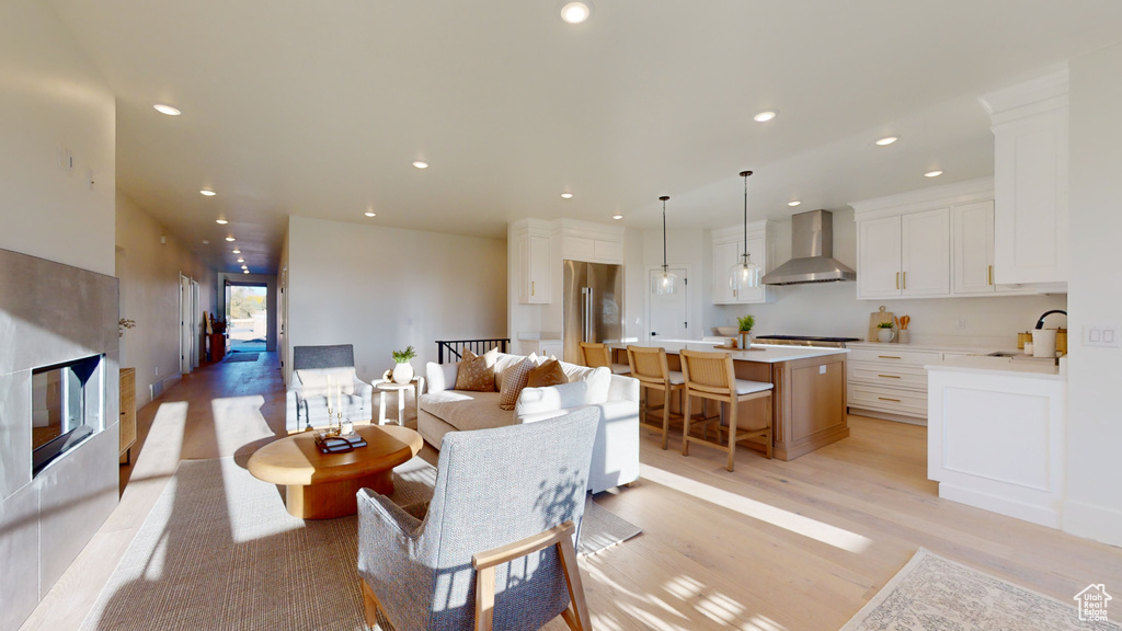Living room with light wood finished floors and recessed lighting