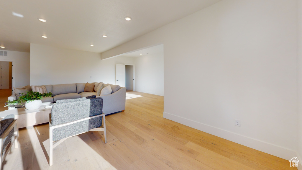 Living room with light wood-style flooring and recessed lighting