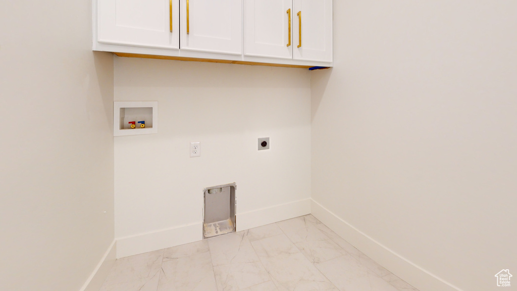 Laundry area featuring cabinet space, hookup for an electric dryer, light marble finish flooring, and hookup for a washing machine