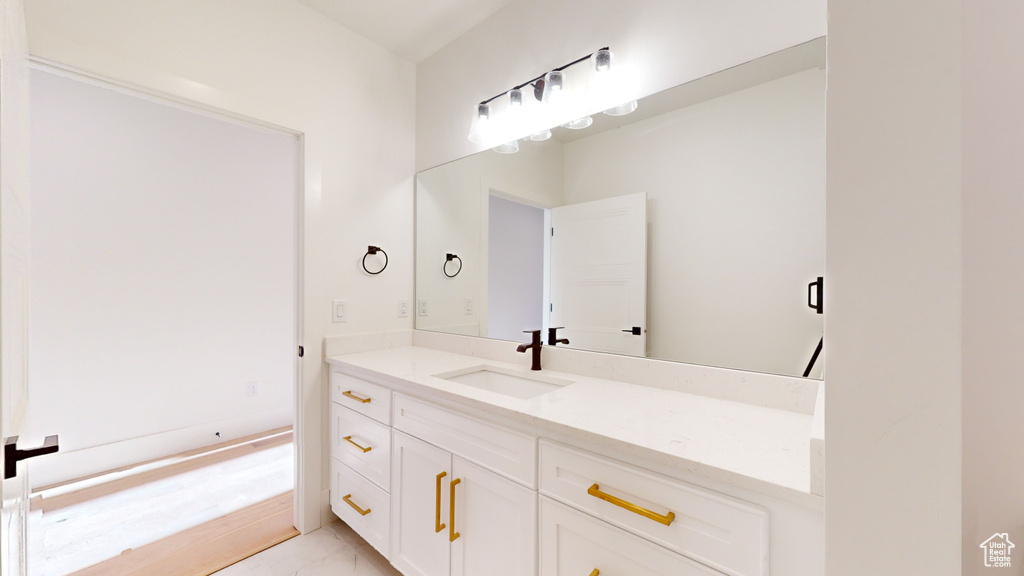 Bathroom with marble look tile flooring and vanity