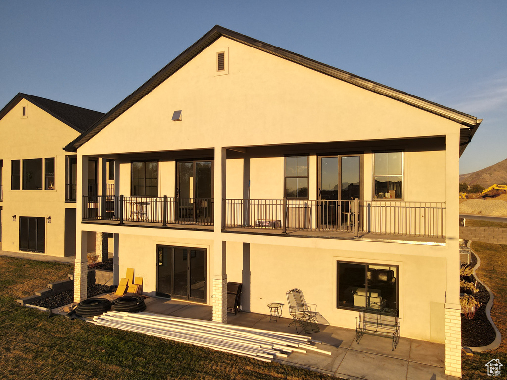 Back of house with a balcony and stucco siding