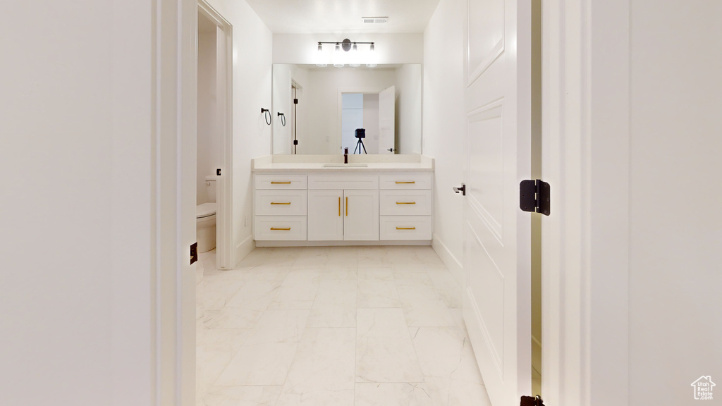 Bathroom featuring marble finish flooring and vanity
