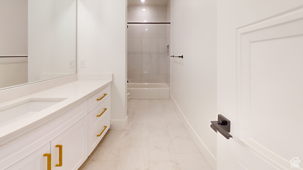 Full bathroom with vanity, marble look tile flooring, and tub / shower combination