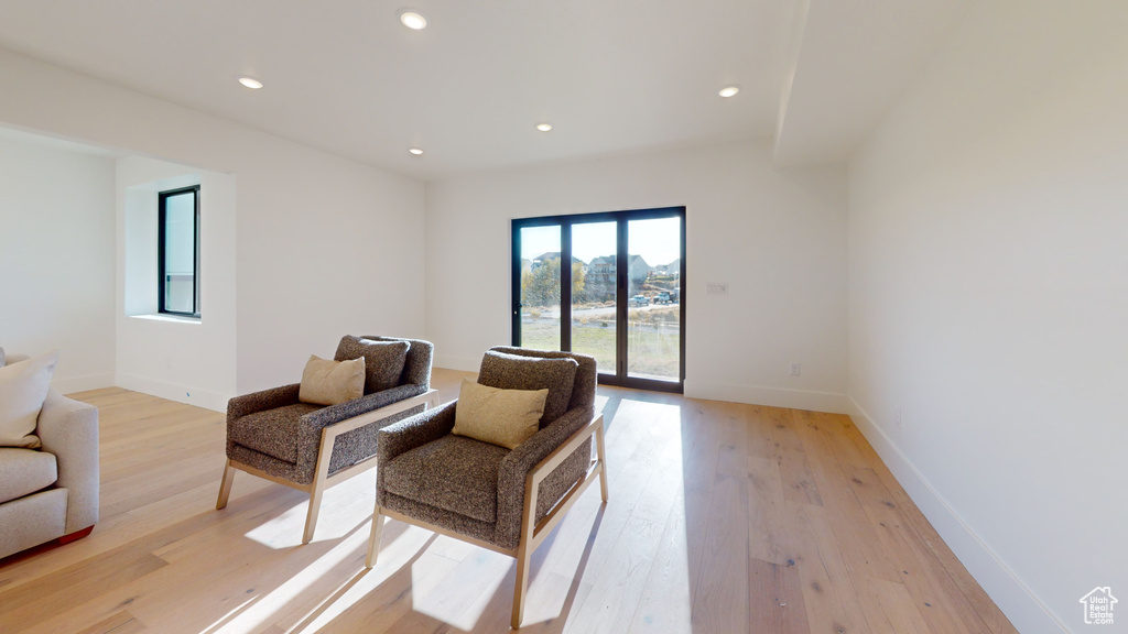 Living area with light wood-style flooring and recessed lighting
