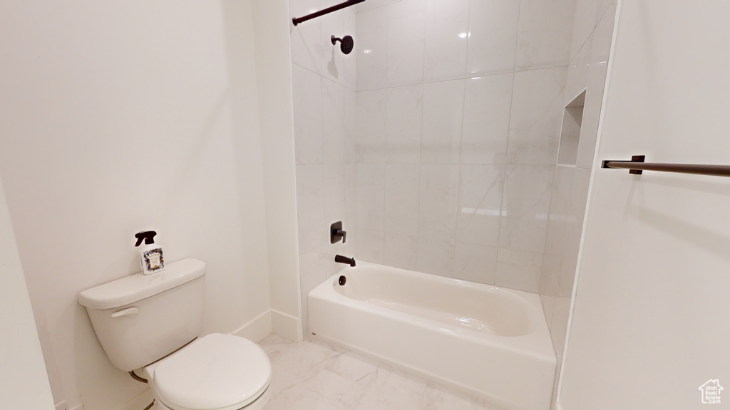 Bathroom featuring shower / bath combination and marble look tile flooring