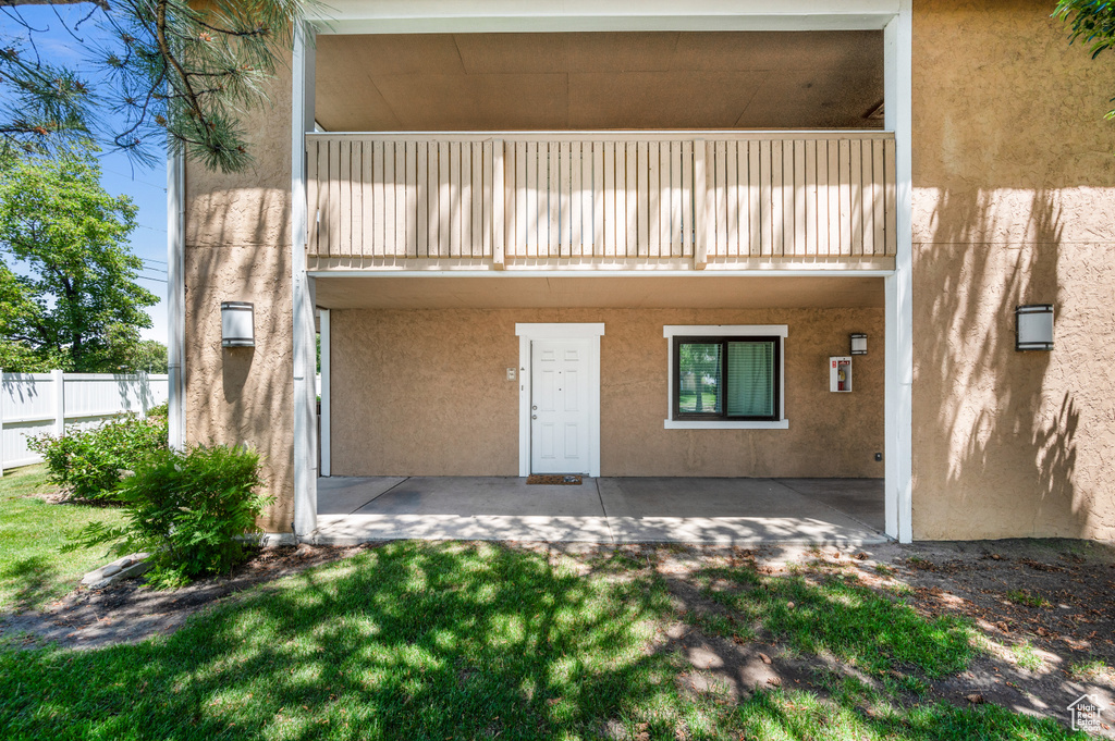 Rear view of house featuring stucco siding and a balcony