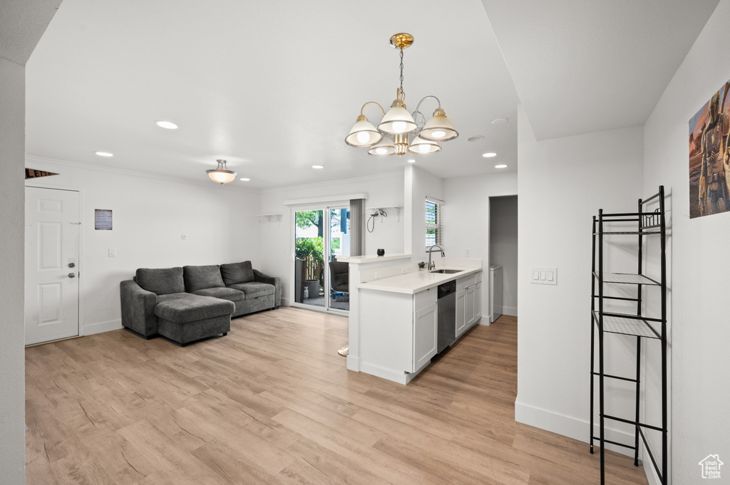 Kitchen with recessed lighting, light countertops, stainless steel dishwasher, light wood-type flooring, and a chandelier