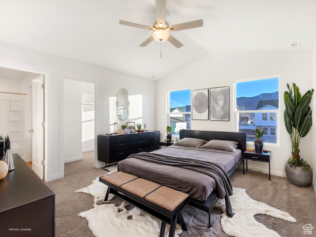 Bedroom featuring light colored carpet, lofted ceiling, and ceiling fan