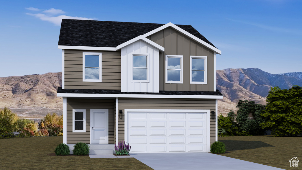 Traditional home featuring board and batten siding, driveway, a mountain view, an attached garage, and a front lawn