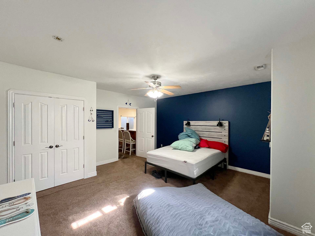 Bedroom with carpet, a closet, and a ceiling fan