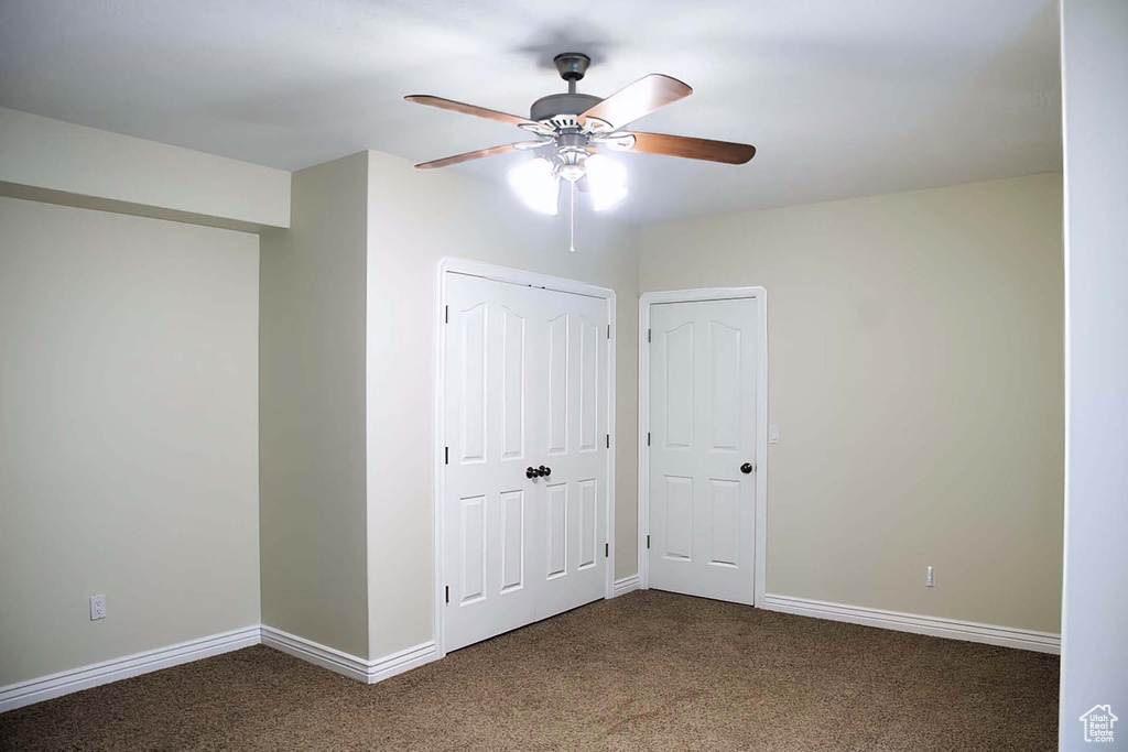 Unfurnished bedroom featuring carpet, a closet, and a ceiling fan