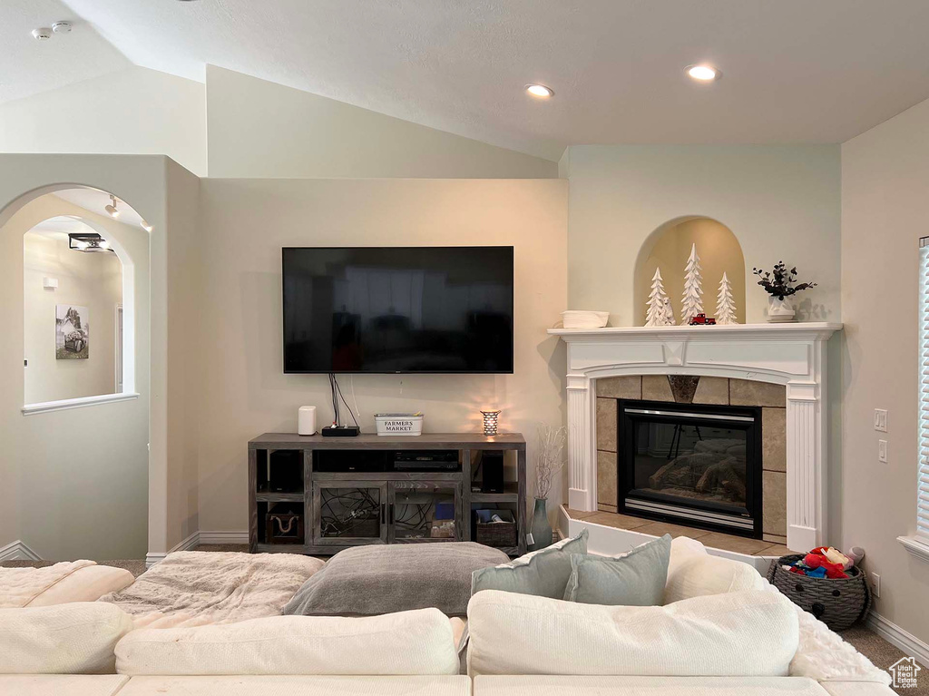 Living room featuring lofted ceiling, recessed lighting, and a fireplace
