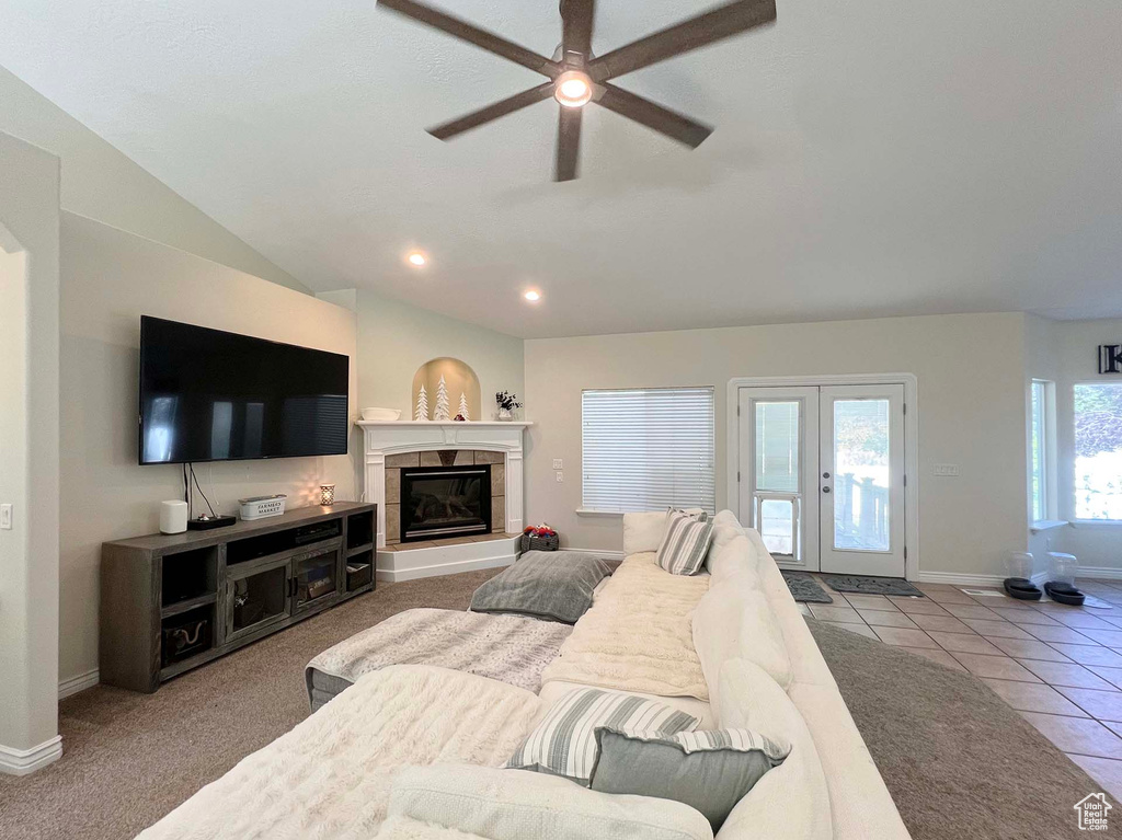 Living room with a ceiling fan, a tile fireplace, tile patterned flooring, recessed lighting, and vaulted ceiling