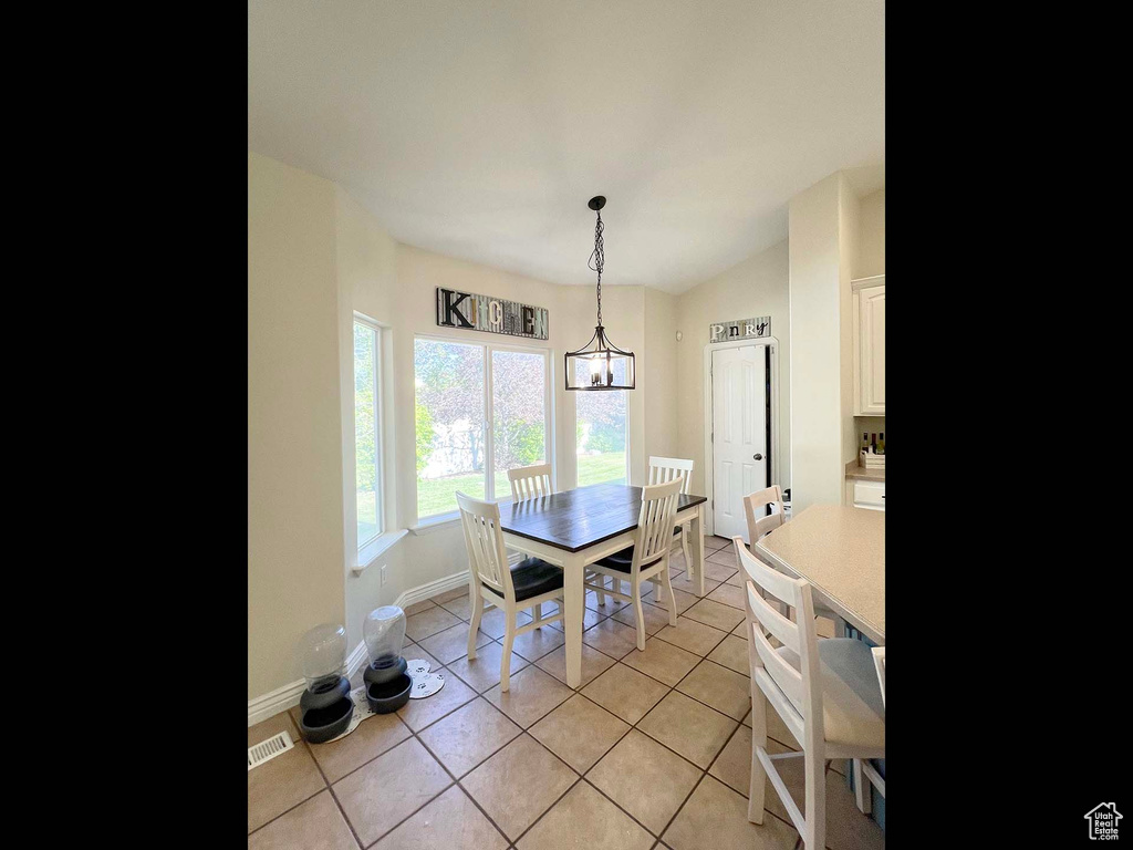 Dining room featuring light tile patterned floors and vaulted ceiling
