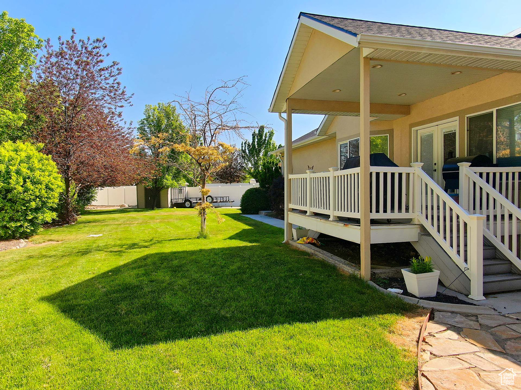View of yard featuring a deck and french doors