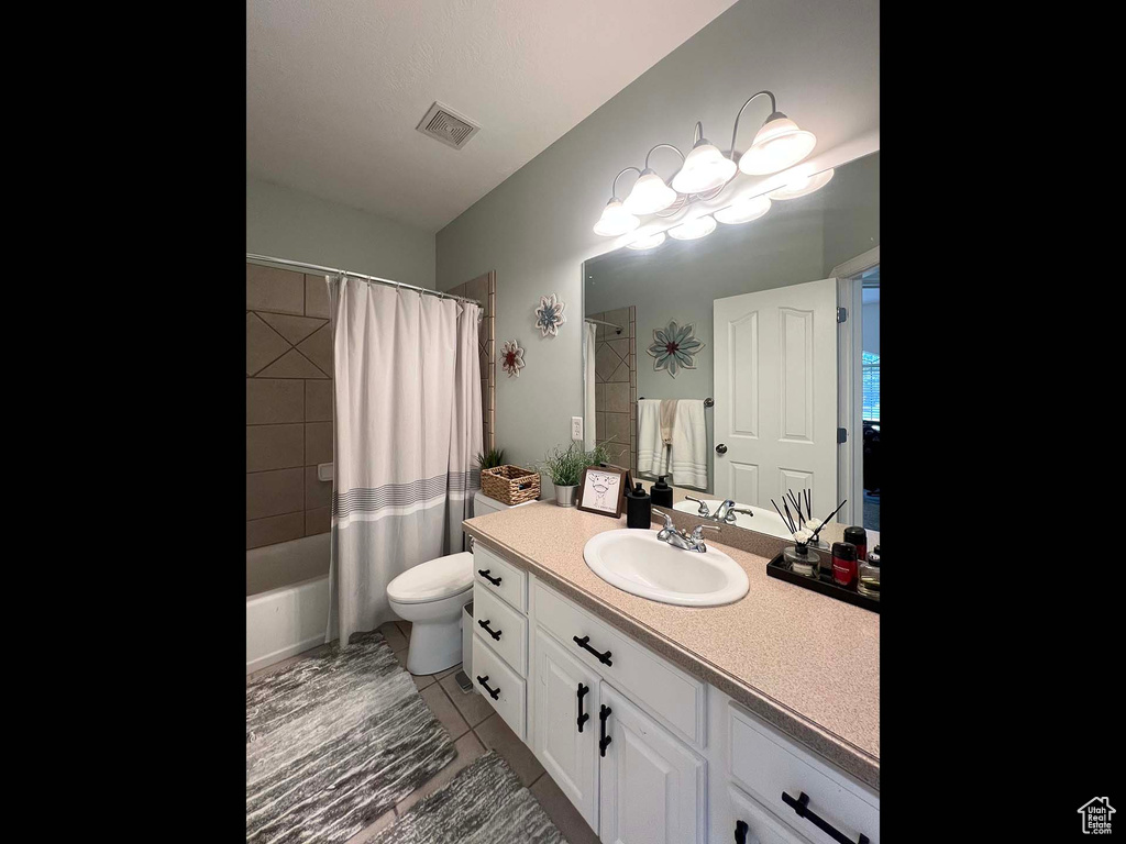 Full bathroom with vanity, shower / tub combo, and tile patterned floors