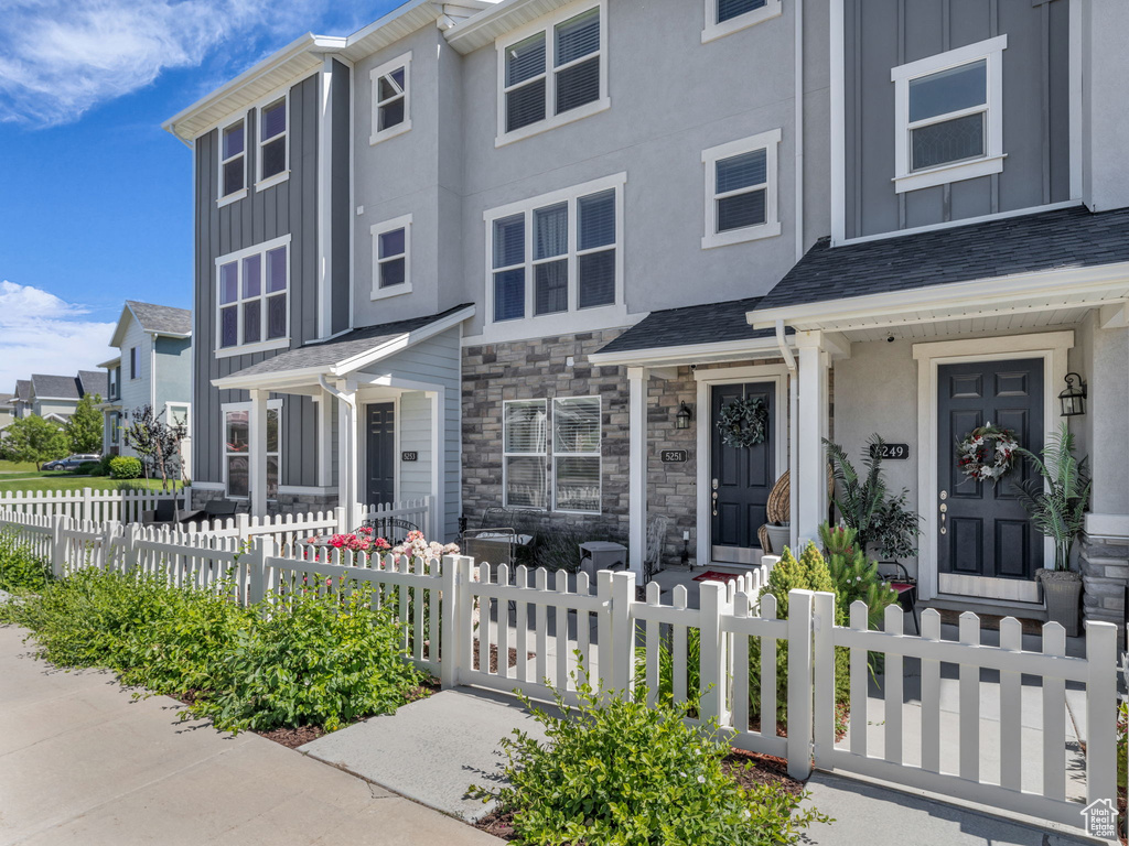 Townhome / multi-family property featuring board and batten siding and stone siding