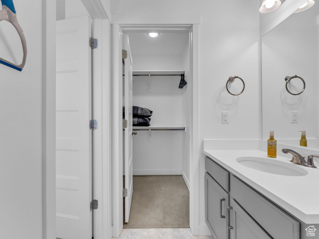 Bathroom with vanity and a walk in closet