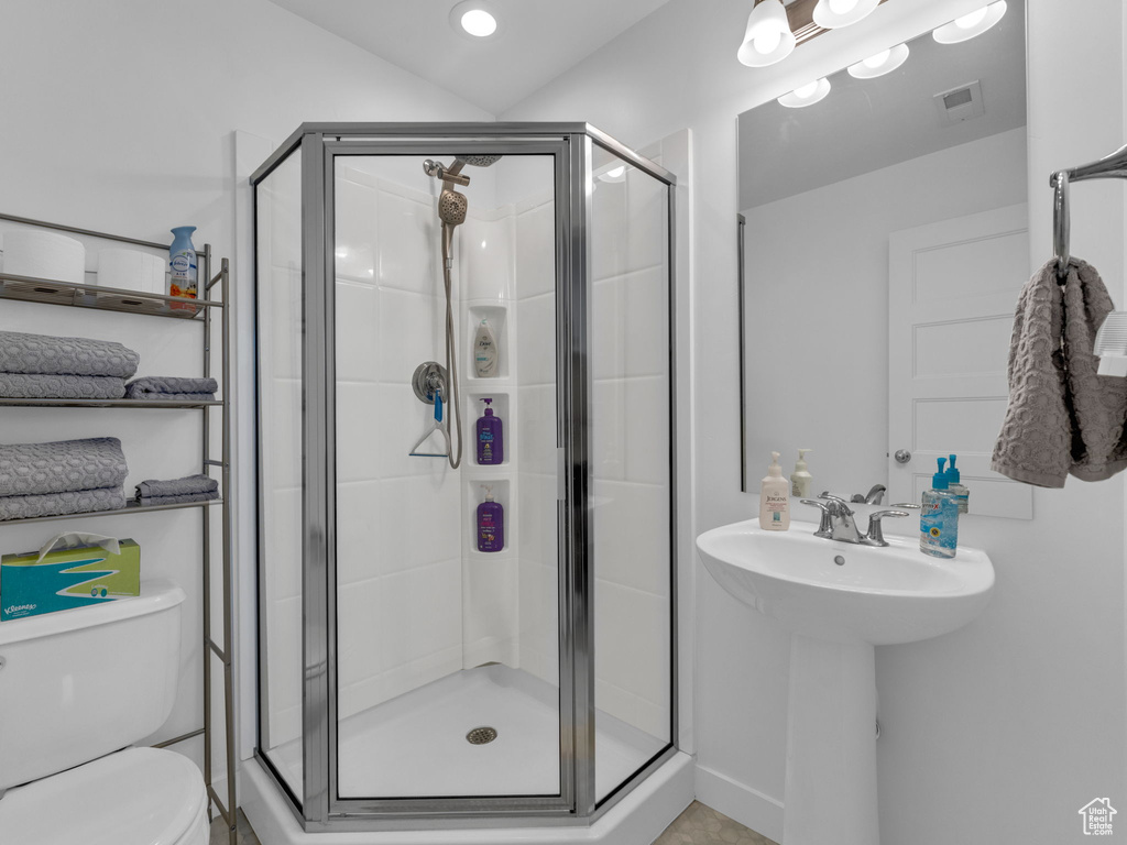 Full bath featuring toilet and a stall shower