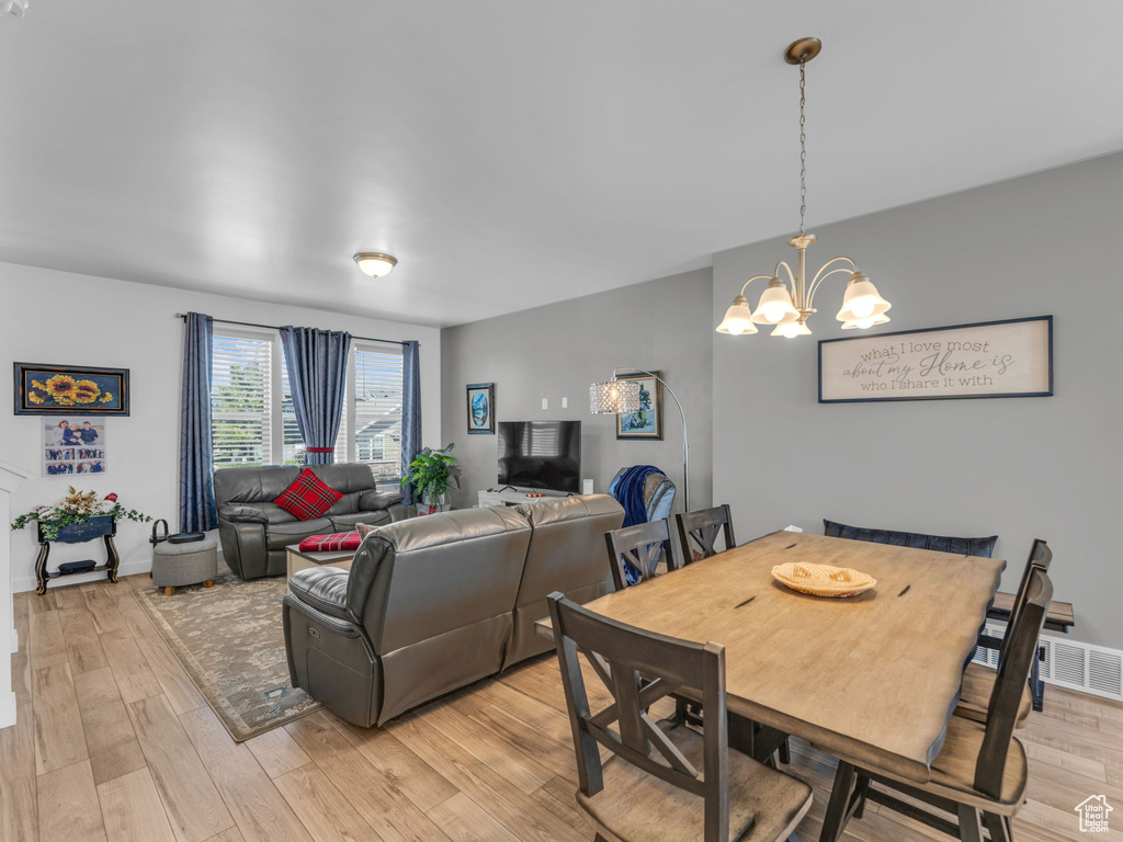 Dining space with light wood-style flooring and a chandelier