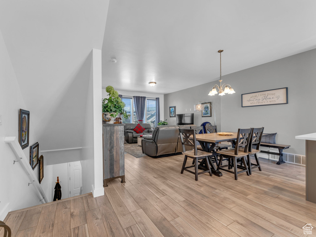 Dining area featuring light wood-style floors and a chandelier