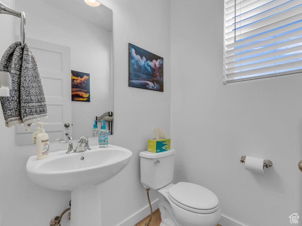 Half bath featuring baseboards and wood finished floors