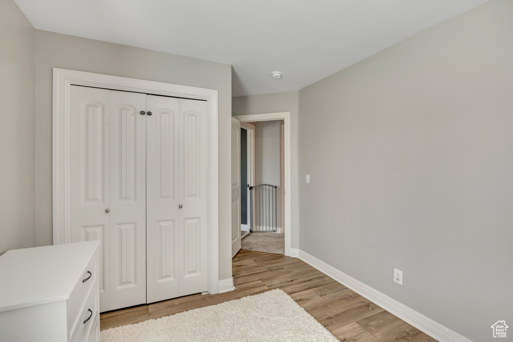 Unfurnished bedroom with light wood-style flooring and a closet