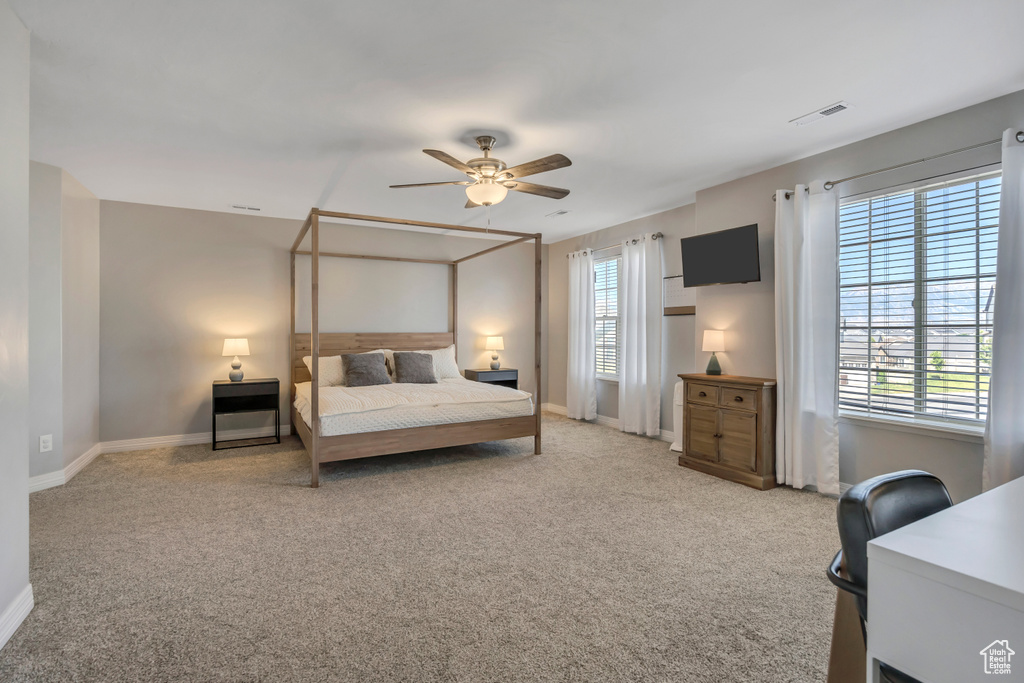 Bedroom with multiple windows, carpet floors, and ceiling fan