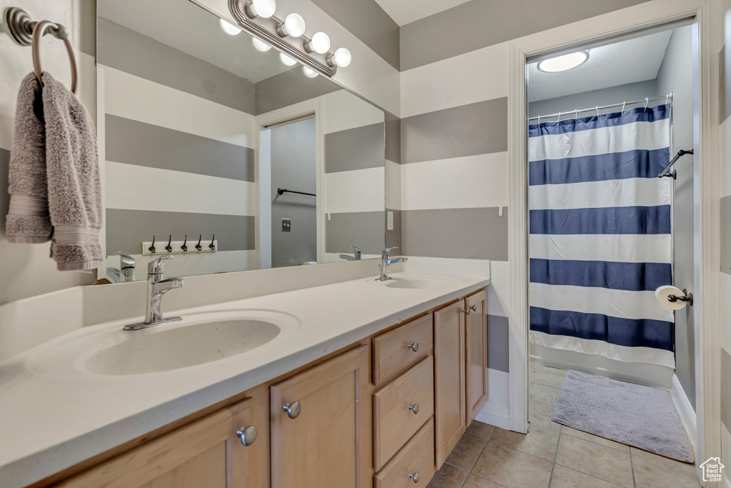 Full bath featuring tile patterned floors, double vanity, and curtained shower