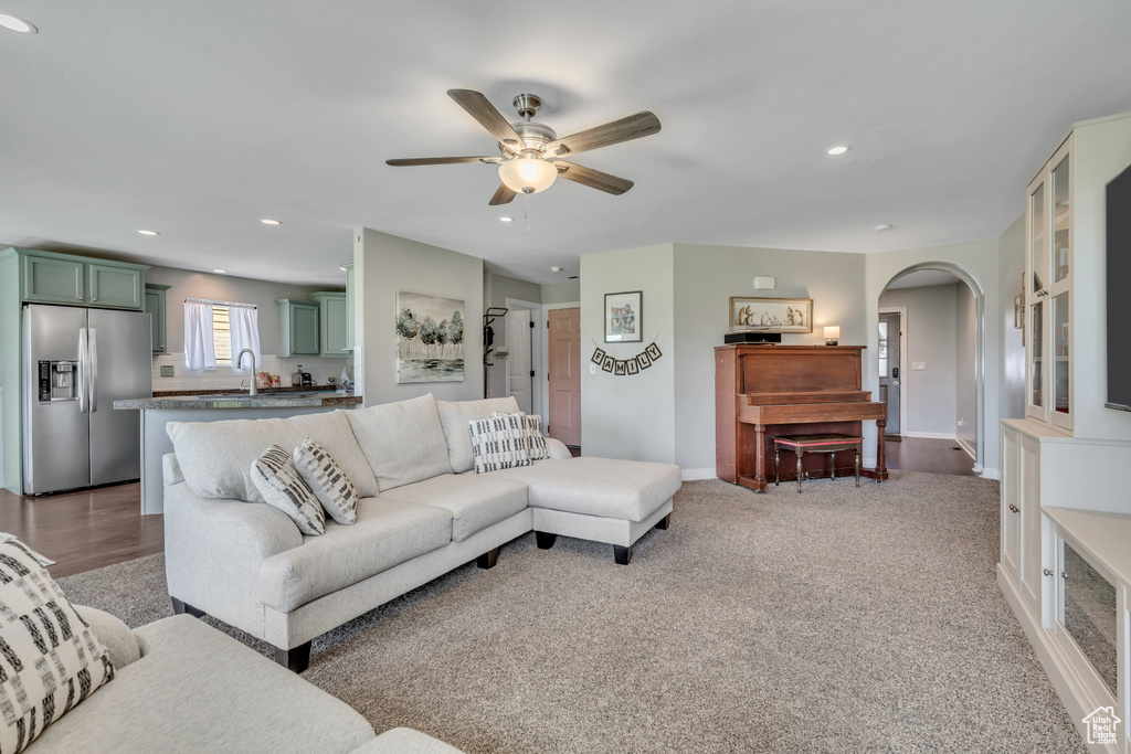 Living room with arched walkways, ceiling fan, and recessed lighting