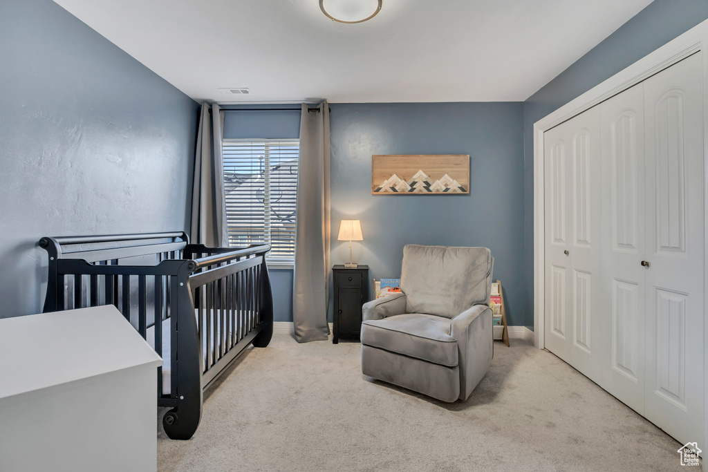 Bedroom with carpet floors, a closet, and a crib