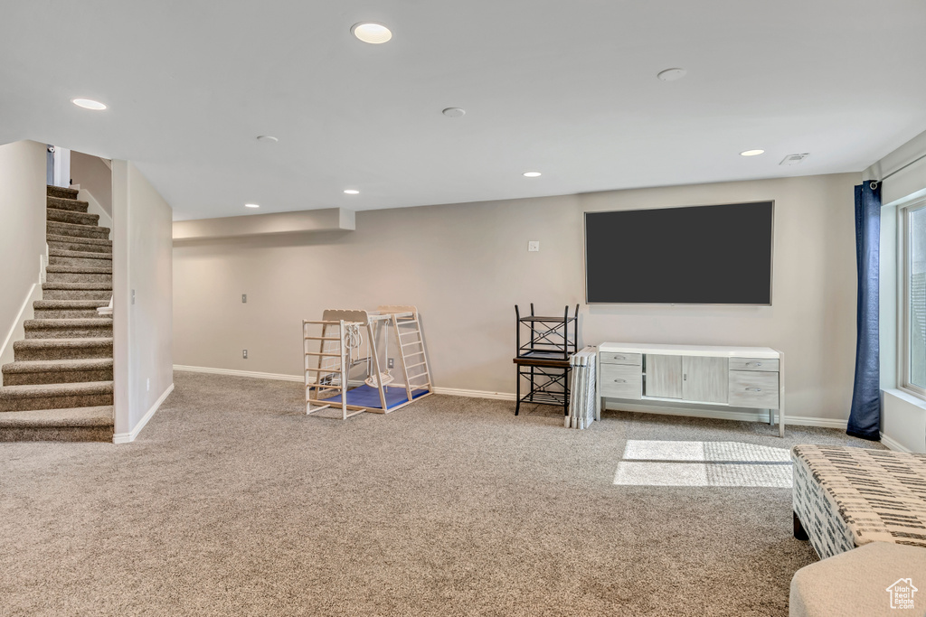 Below grade area with carpet, stairs, and recessed lighting