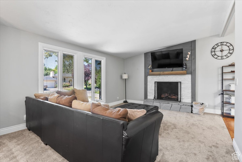 Living room with a stone fireplace and carpet flooring