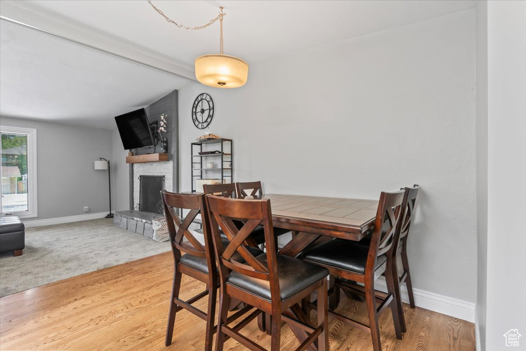 Dining area featuring a stone fireplace and light wood-type flooring