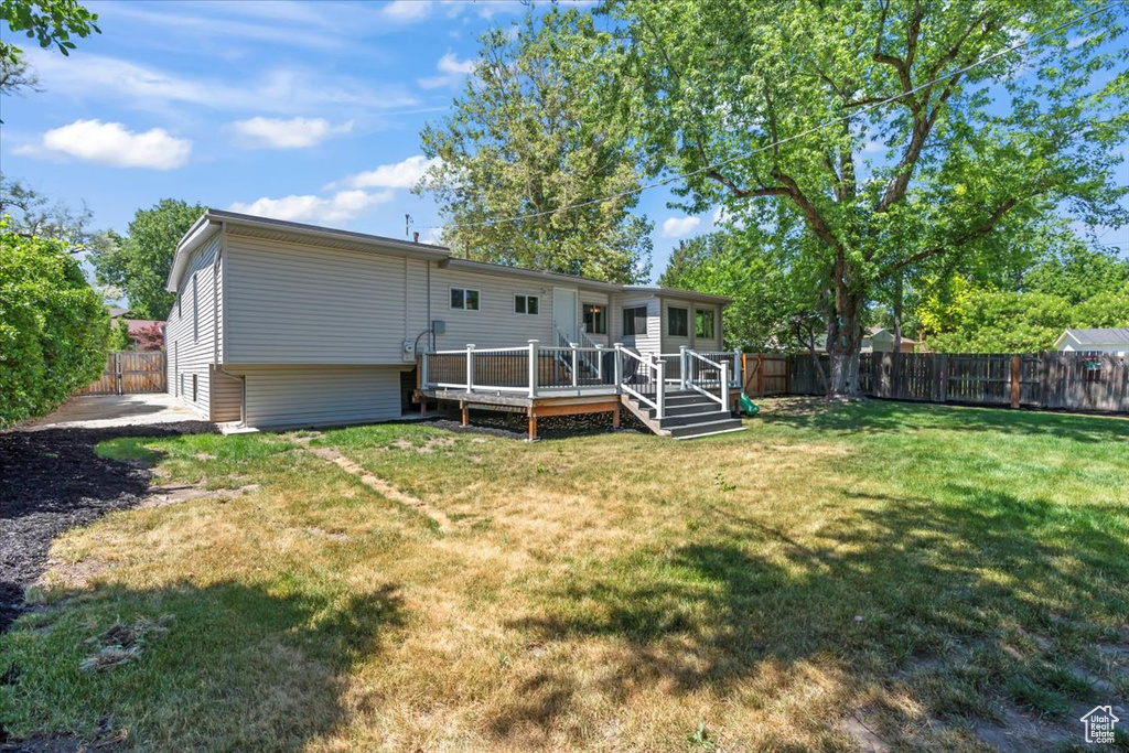 Back of house with a fenced backyard and a wooden deck