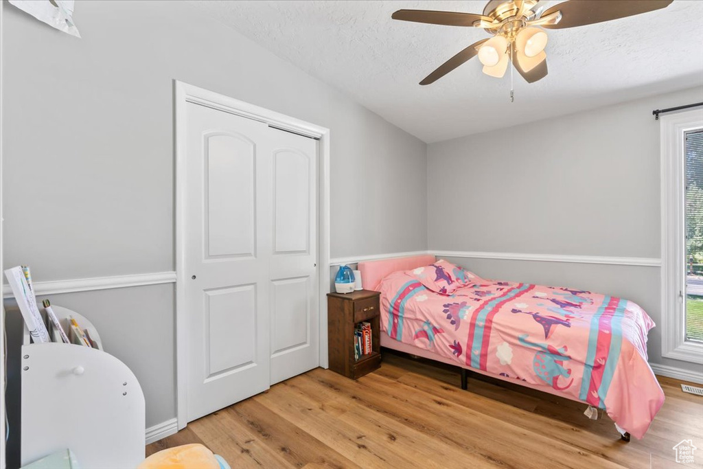 Bedroom featuring wood finished floors, a textured ceiling, and a ceiling fan