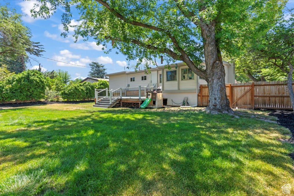 Rear view of house with a deck and a fenced backyard